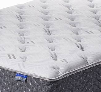 close-up of a mattress with a gray quilted top and patterned dark gray sides