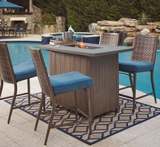 four patio chairs around a fire pit table by a pool