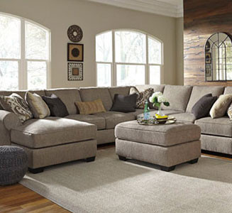 living room with large gray sectional sofa and ottoman