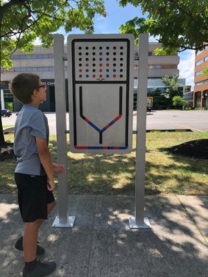 A boy plays a four-in-a-row game installed in the Play Walk