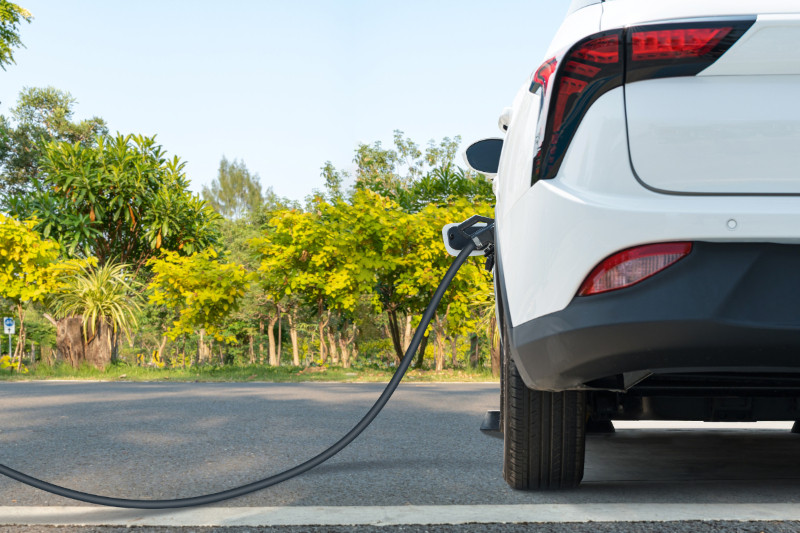 white electric vehicle plugged into charging station