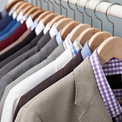 men's suits neatly hung in closet