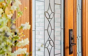 Close-up of a residential entry door in Rochester NY with glass panels and a metal handle.