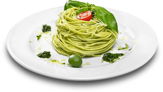 A plate of pesto spaghetti topped with basil and a cherry tomato.