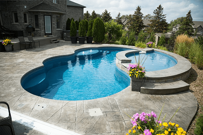 Luxury pool with attached spa and patio seating.
