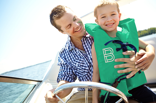 A man driving his boat with his son