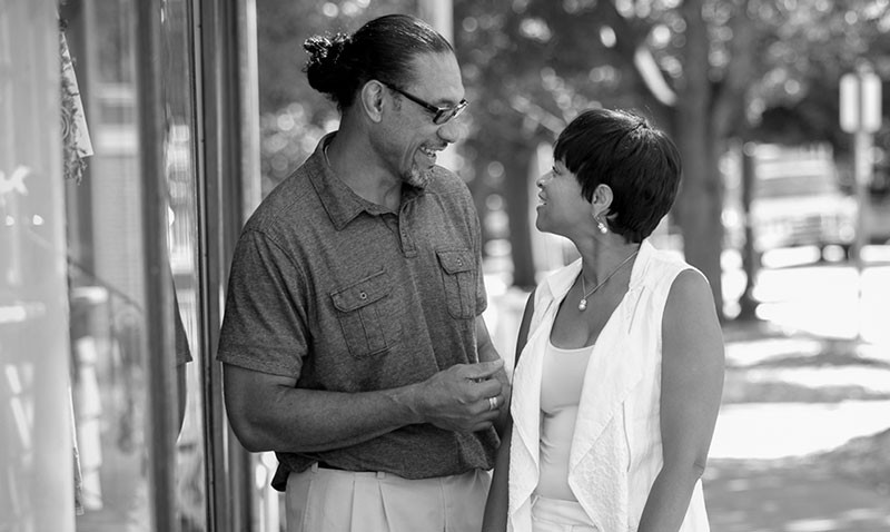 woman and man talking on sidewalk