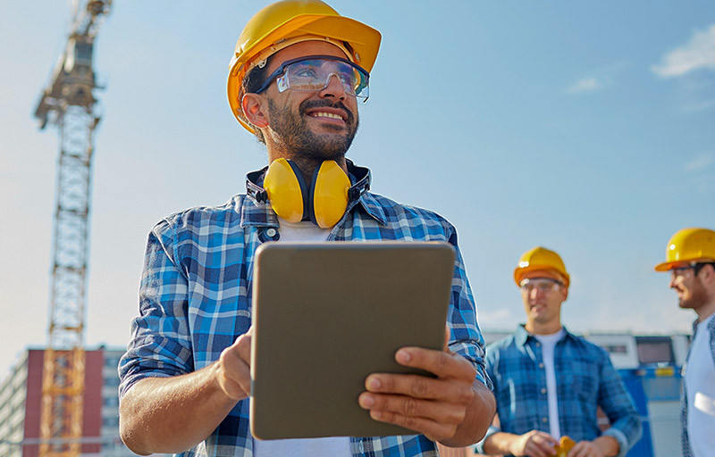 Construction workers on commercial build site wearing hard hats 