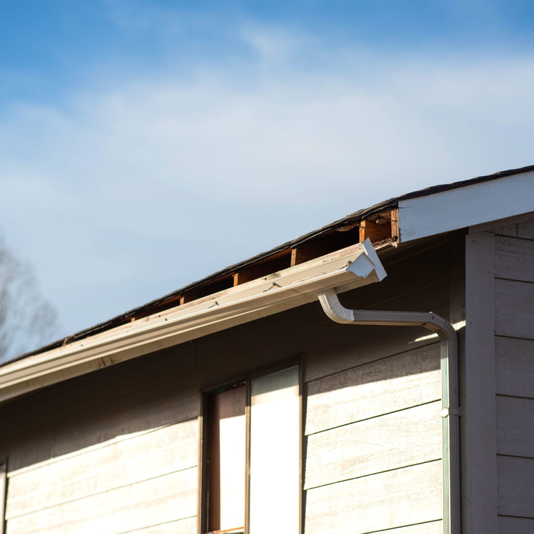 An old gutter breaking away from the roof