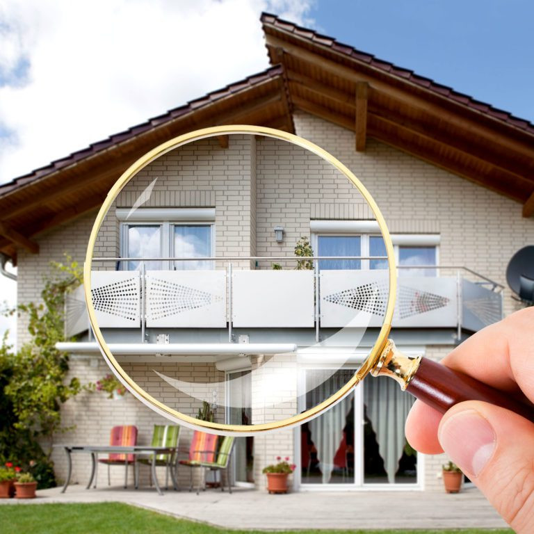 Magnifying glass in front of home