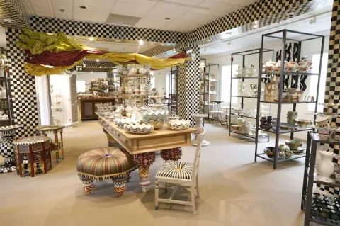 A vibrant store displays colorful, patterned ceramics and furniture with checkered decor accents.