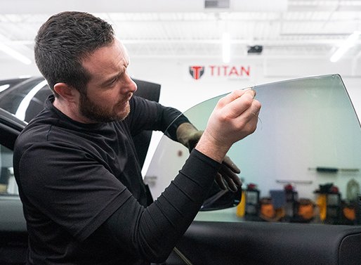 titan motorworks employee tinting a car window