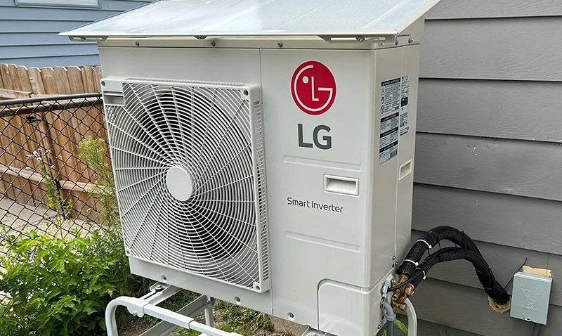 Outdoor LG Smart Inverter air conditioning unit installed next to a house with a gray wall.