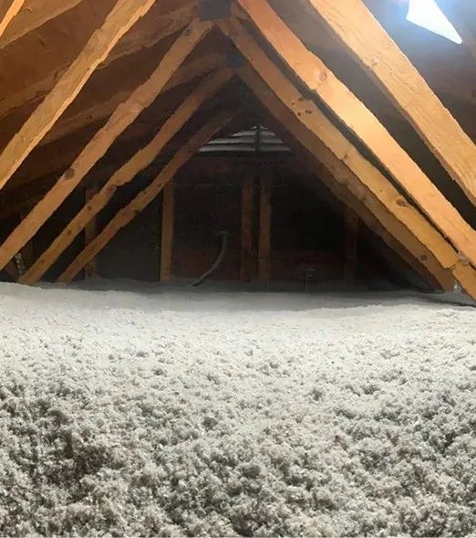 person in protective gear spraying foam insulation onto a wall