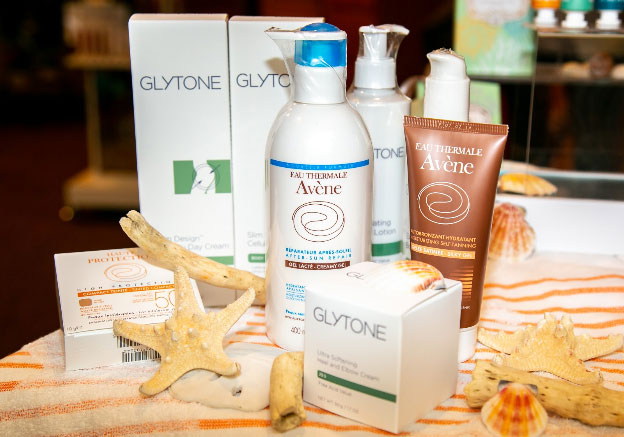 variety of glytone and avene products with shells and starfish