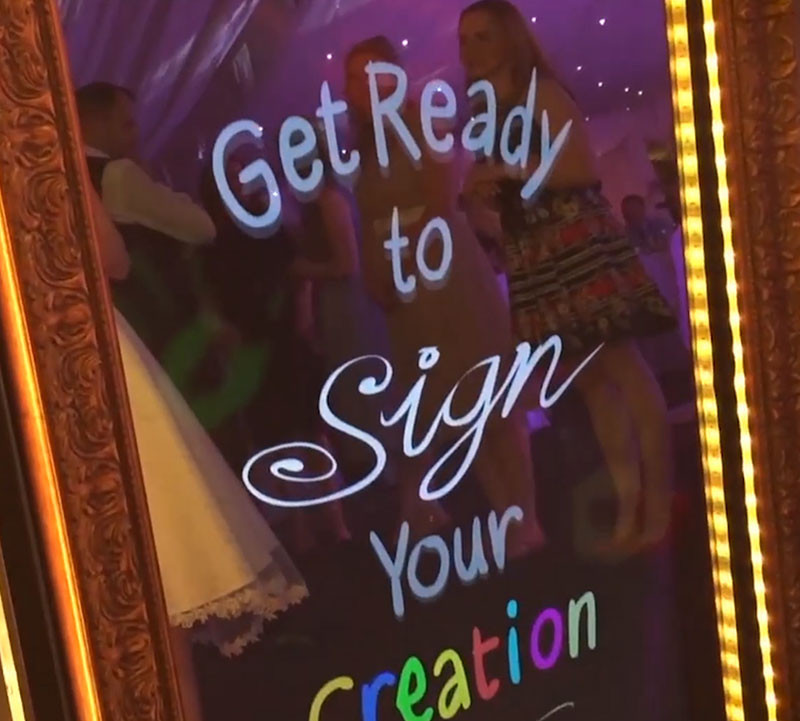 Mirror Photo Booth Displaying "Get Ready to Sign Your Creation" 