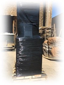 product wrapped in black plastic on pallet for shipping