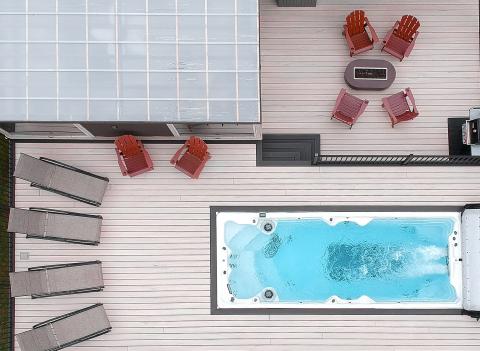 pdc spas swim spa installed into deck with patio loungers and dining area