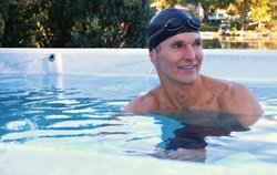 man in swim cap enjoying swim spa