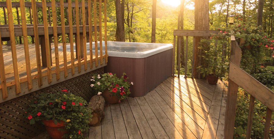 reliable pdc spas hot tub on deck surrounded by potted flowers