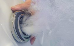 close up of a person adjusting underwater hot tub jet