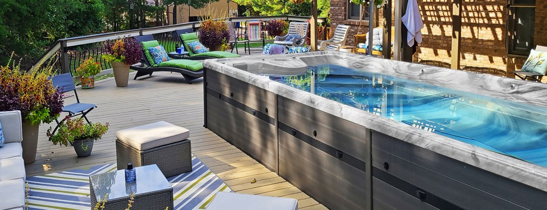 pdc spas swim spa installed partially in deck surrounded by patio furniture