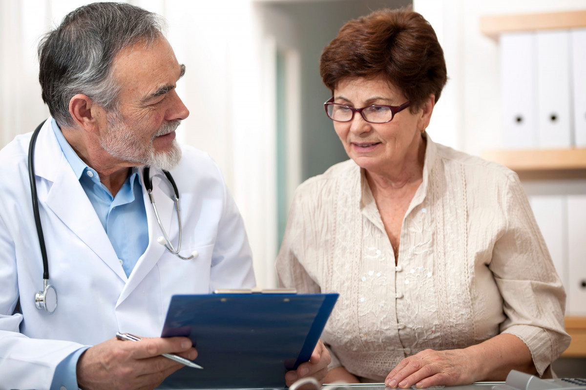 Elder doctor and patient discussing chart