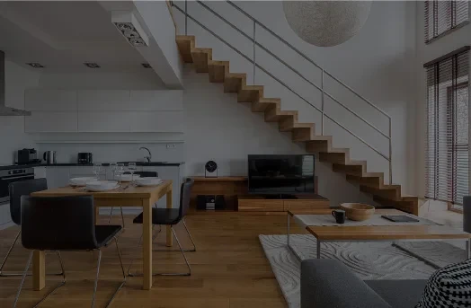 Modern open-plan living room and kitchen with wooden stairs and minimalist décor.