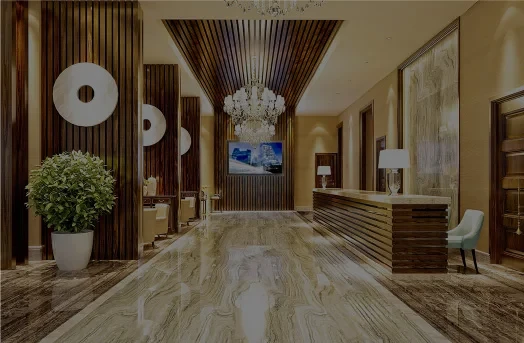 Luxurious hotel lobby with chandeliers, marble floors, wood accents, and a reception desk.