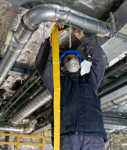 A family of four sits together on a couch, smiling and talking in a bright living room.