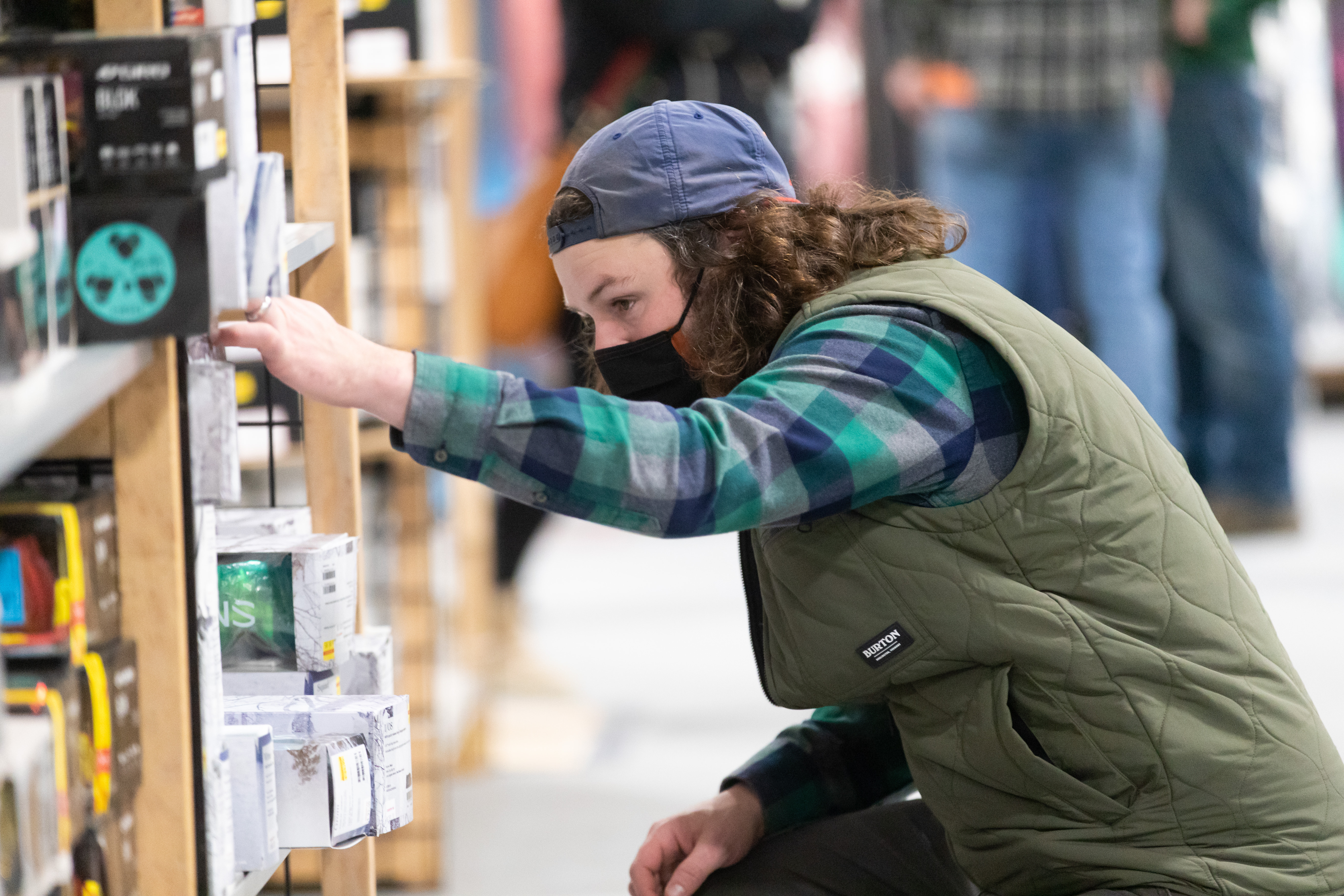 person shopping reaching for item on shelf