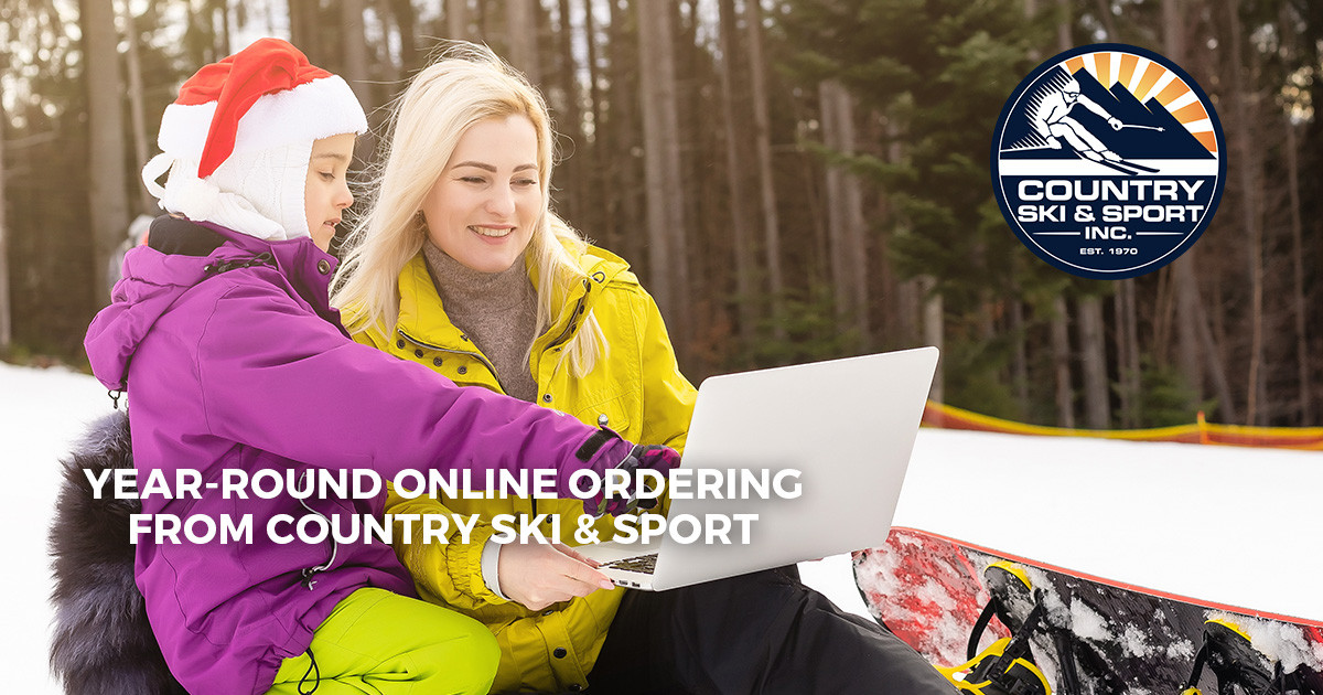 mother and daughter on laptop snowboard on slopes