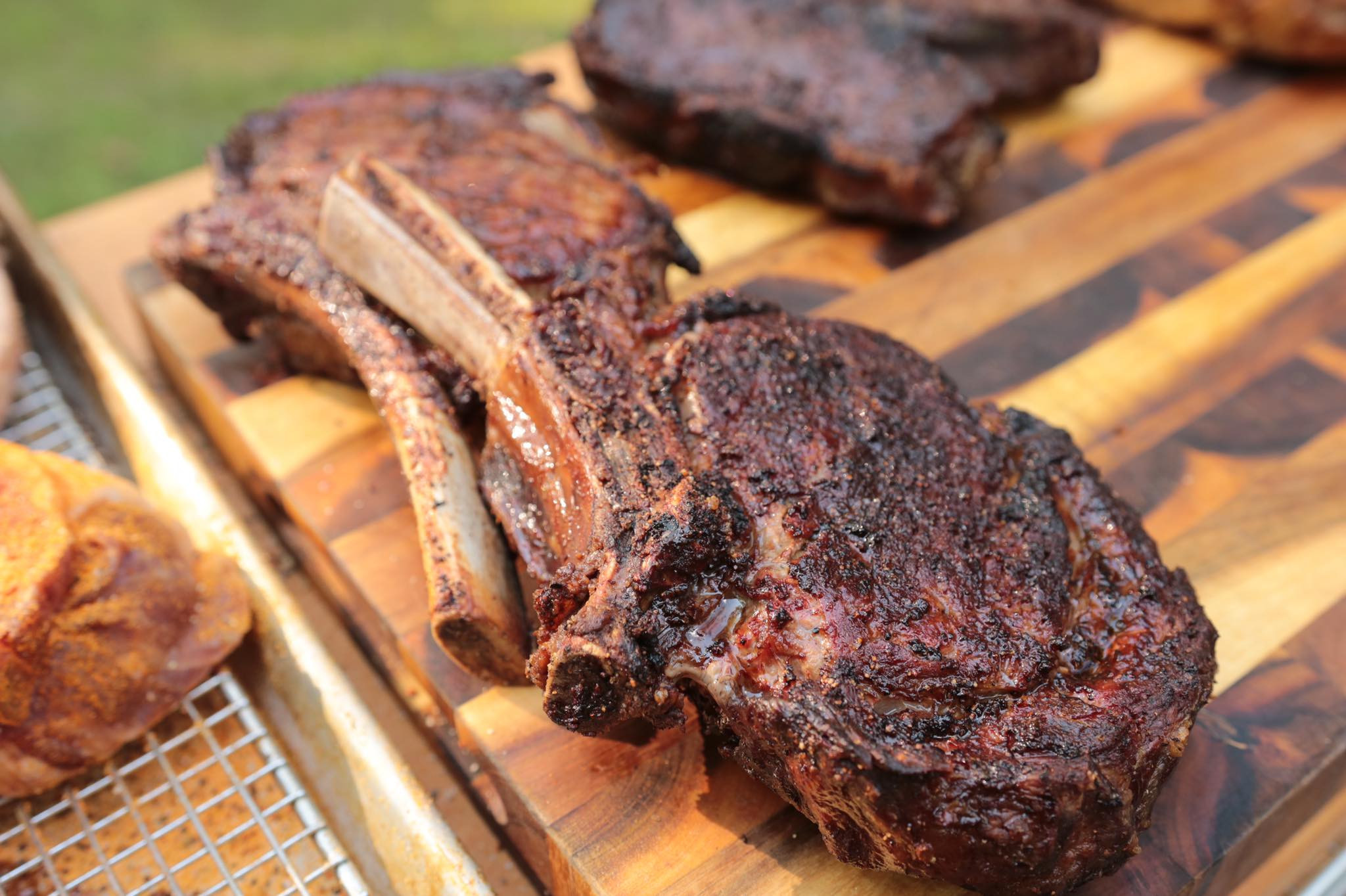 two t-bone steaks on a wooden cutting board