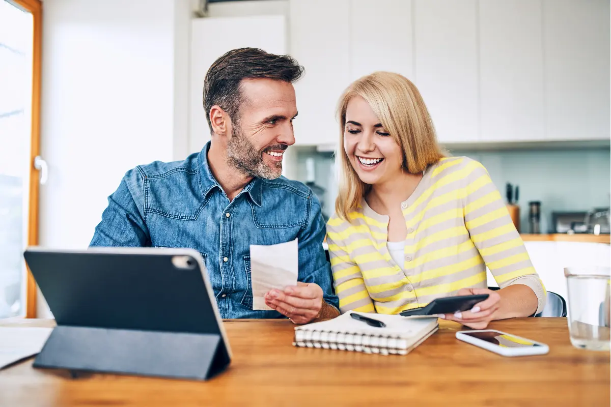 man and woman at kitchen table calculating numbers