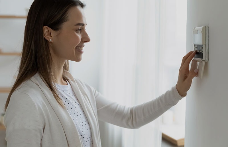 woman adjusting her thermostat