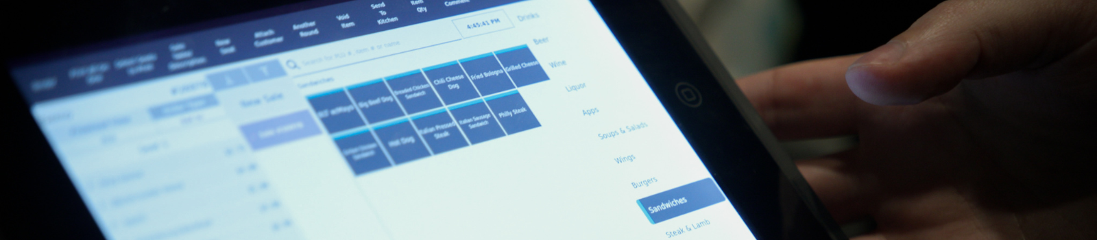 A person uses a touchscreen tablet displaying a menu with various selectable options.