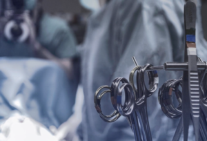 Doctor in surgery with medical equipment standing by