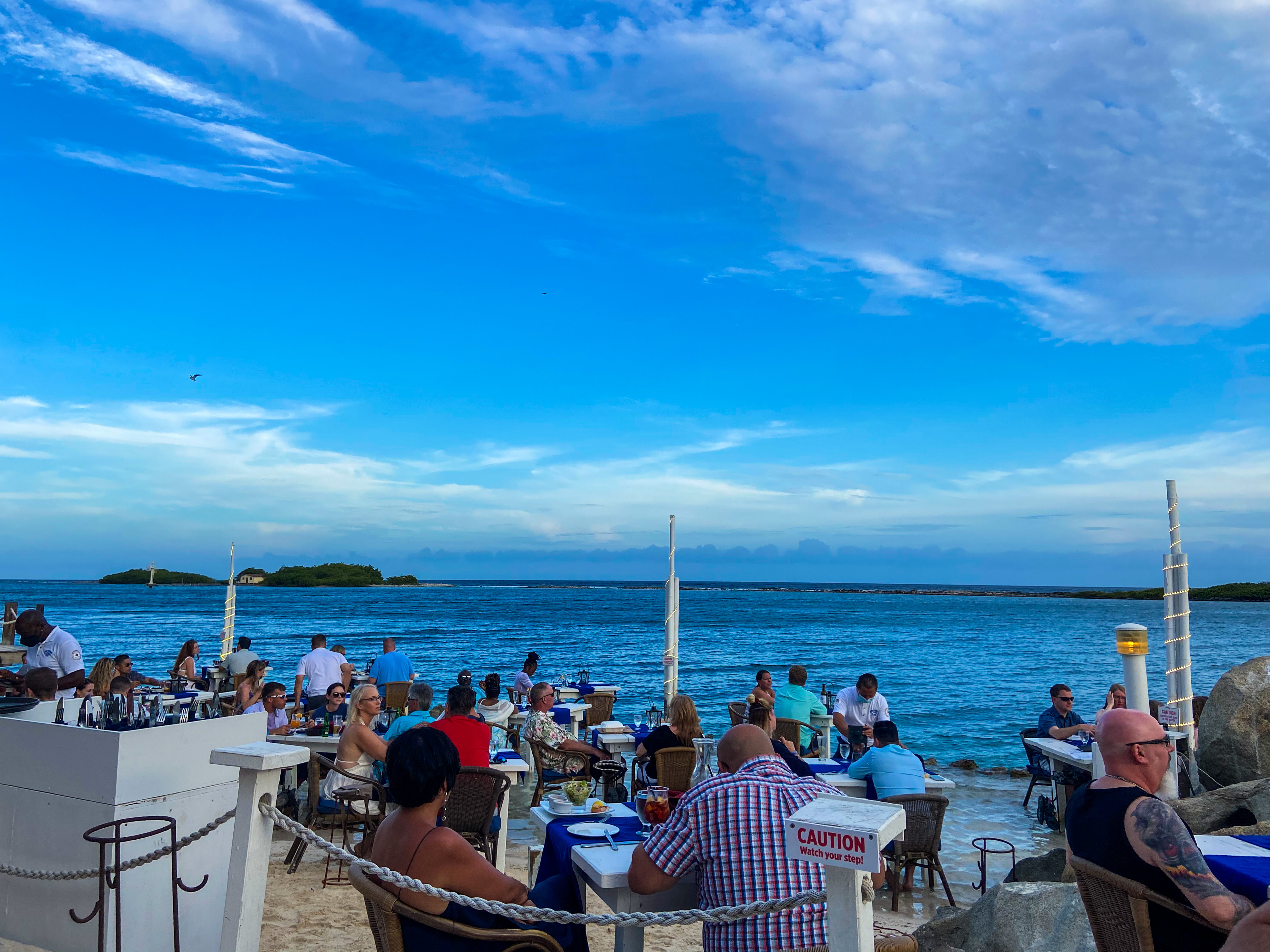 a group of people sitting at tables on a dock